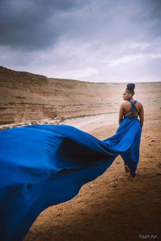 A flying-dress photoshoot in a blue gown against the Egyptian desert