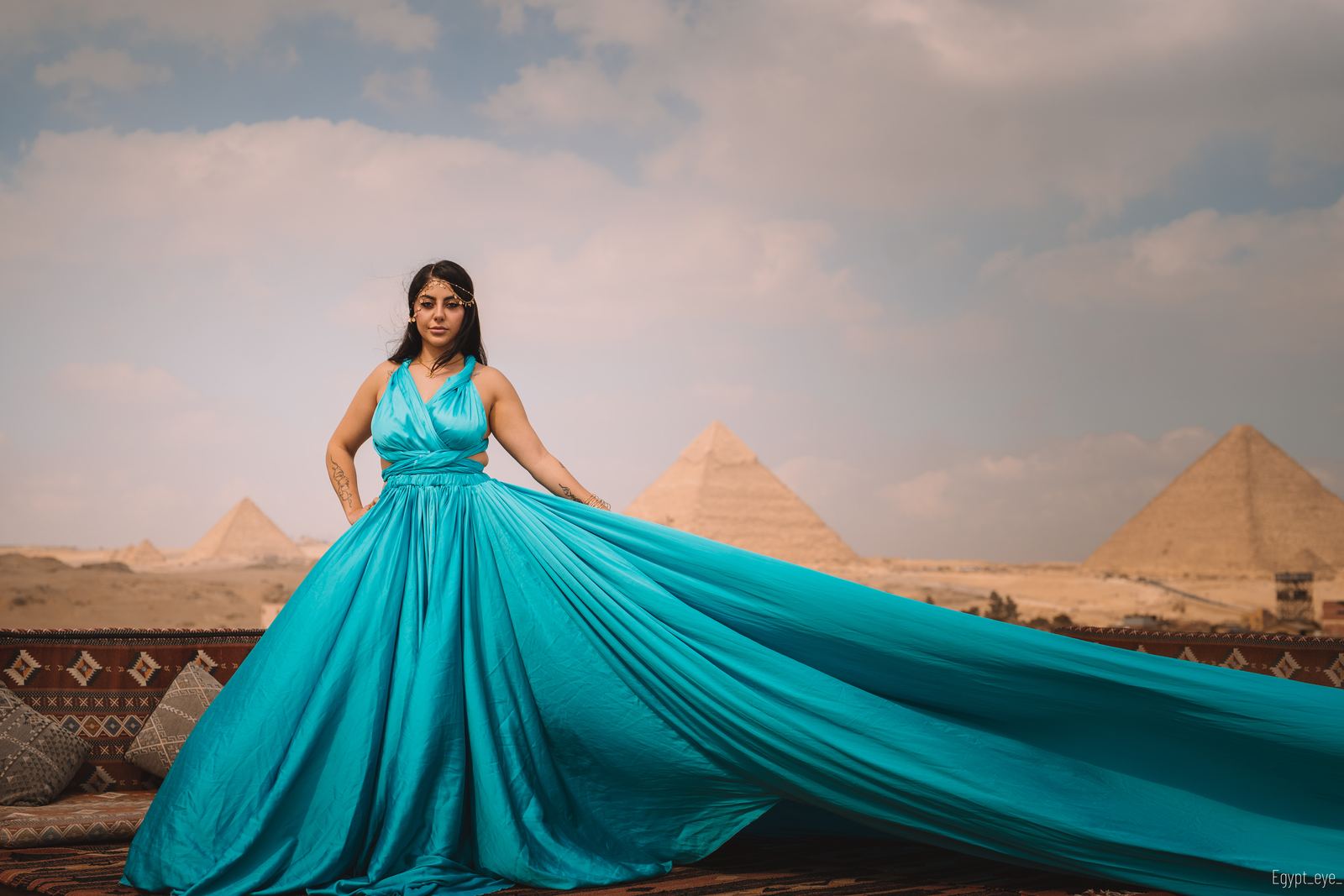 The Aqua dress spread wide across the rooftop, turquoise against the sand and three pyramids