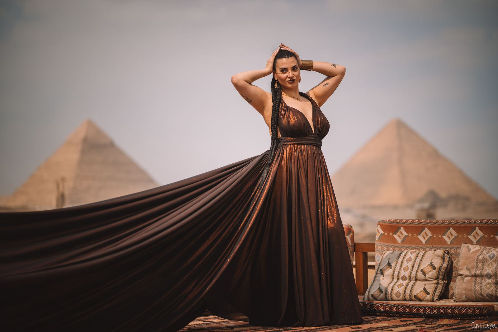The BronZey dress on the rooftop, bronze silk falling away to one side with a pyramid behind